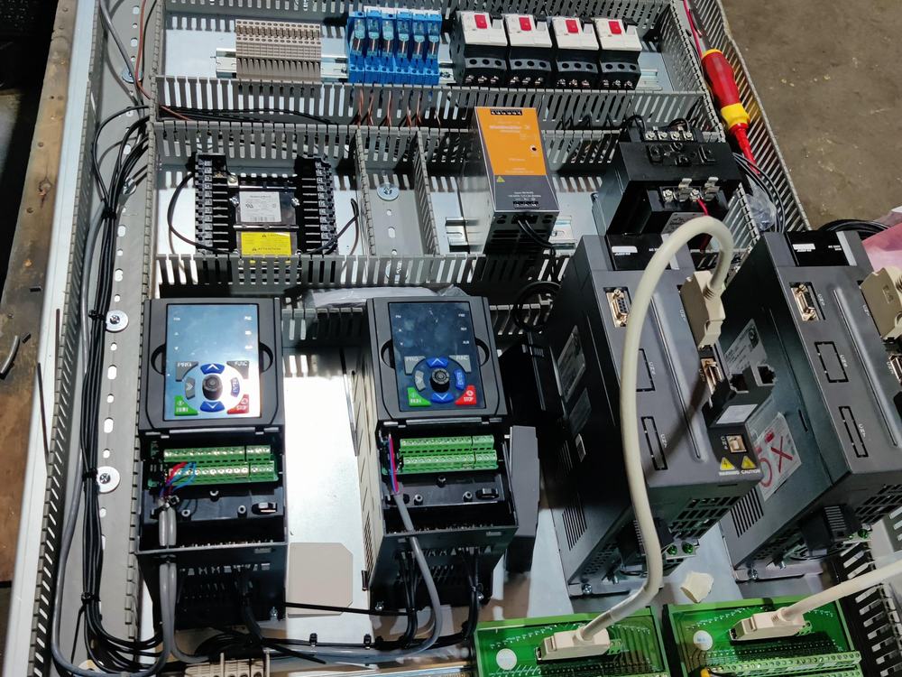 Ingeniero programando desde una laptop junto a la máquina en el piso de planta