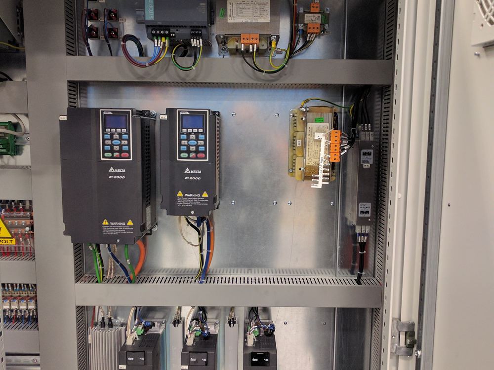 Interior de tablero de control con PLC, dos variadores de frecuencia Delta y tres servodrives cableados sobre riel