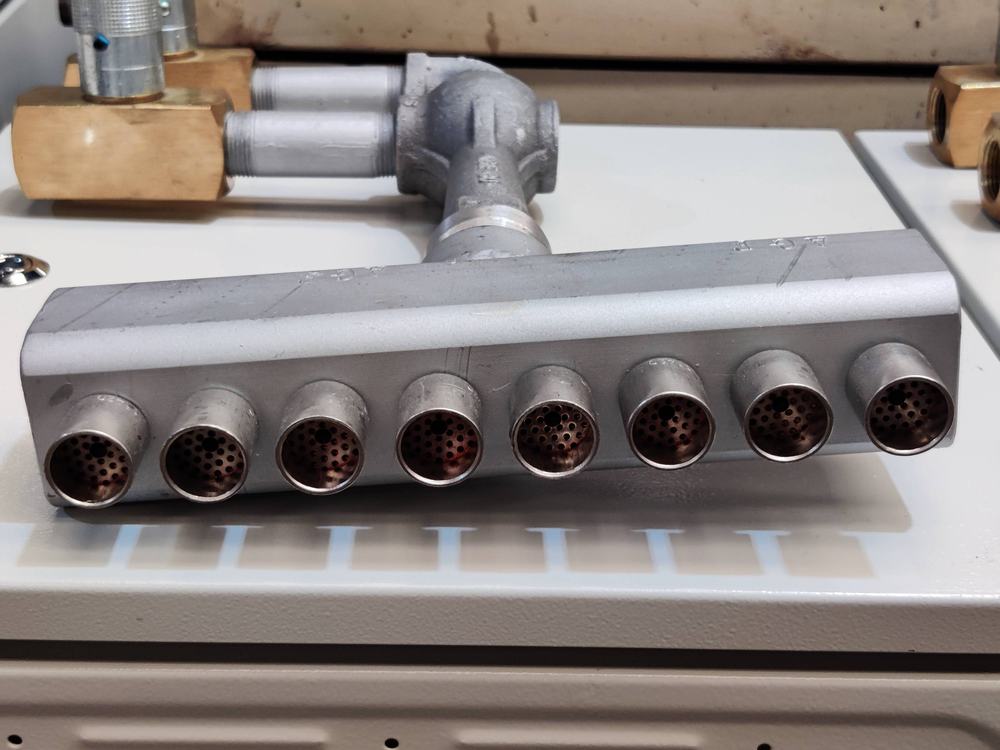 Múltiple de aluminio maquinado con siete alojamientos roscados alineados
