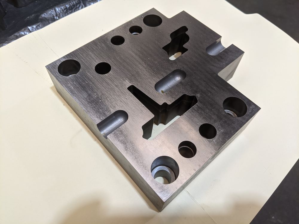 Placa de acero con cavidades y ranuras maquinadas para troquel